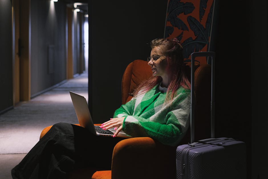 Brussels hotel booking tips — woman with laptop and luggage in hotel hallway making travel arrangements