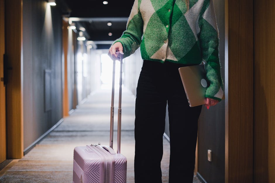 Brussels hotel booking tips — traveller working on laptop in hotel hallway with luggage