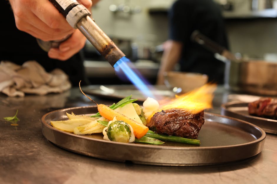 Best restaurants in Brussels — gourmet dish being seared with culinary torch in professional kitchen