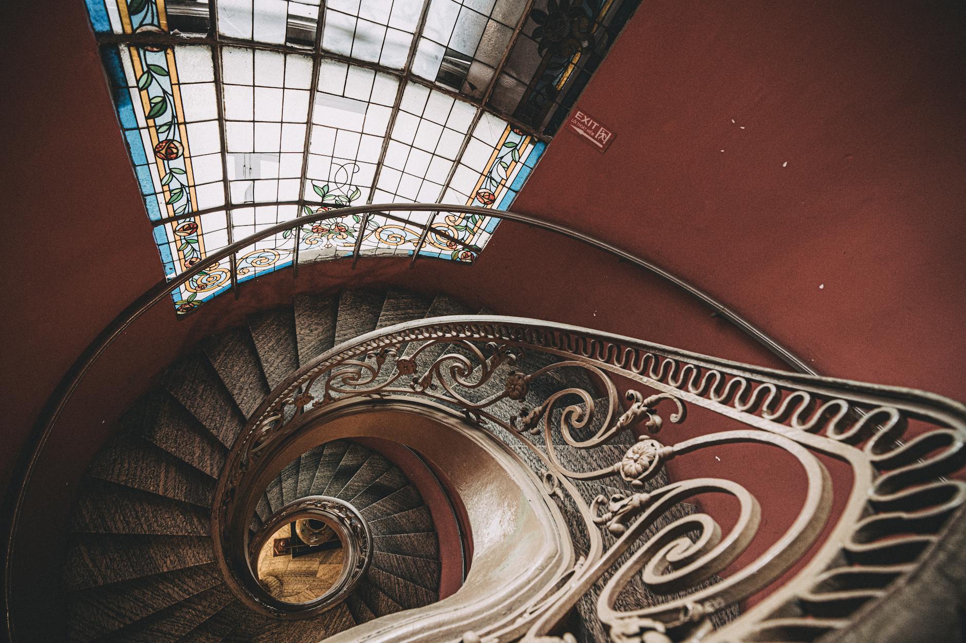 A stunning Art Nouveau interior staircase with flowing ironwork and stained glass