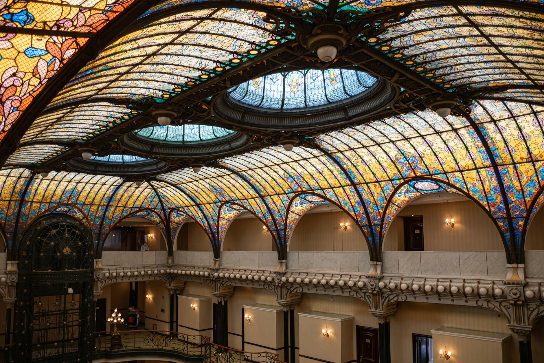 An ornate Art Nouveau stained glass window with flowing designs