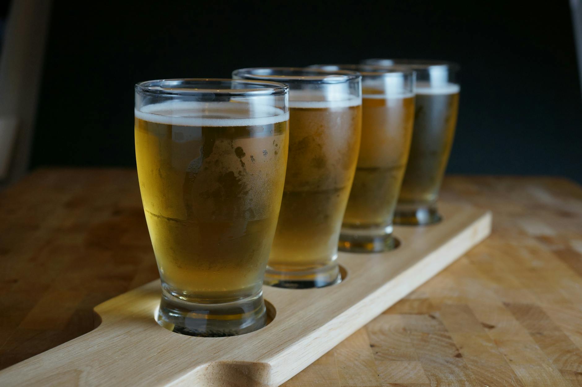 A flight of craft beer glasses lined up for a tasting session