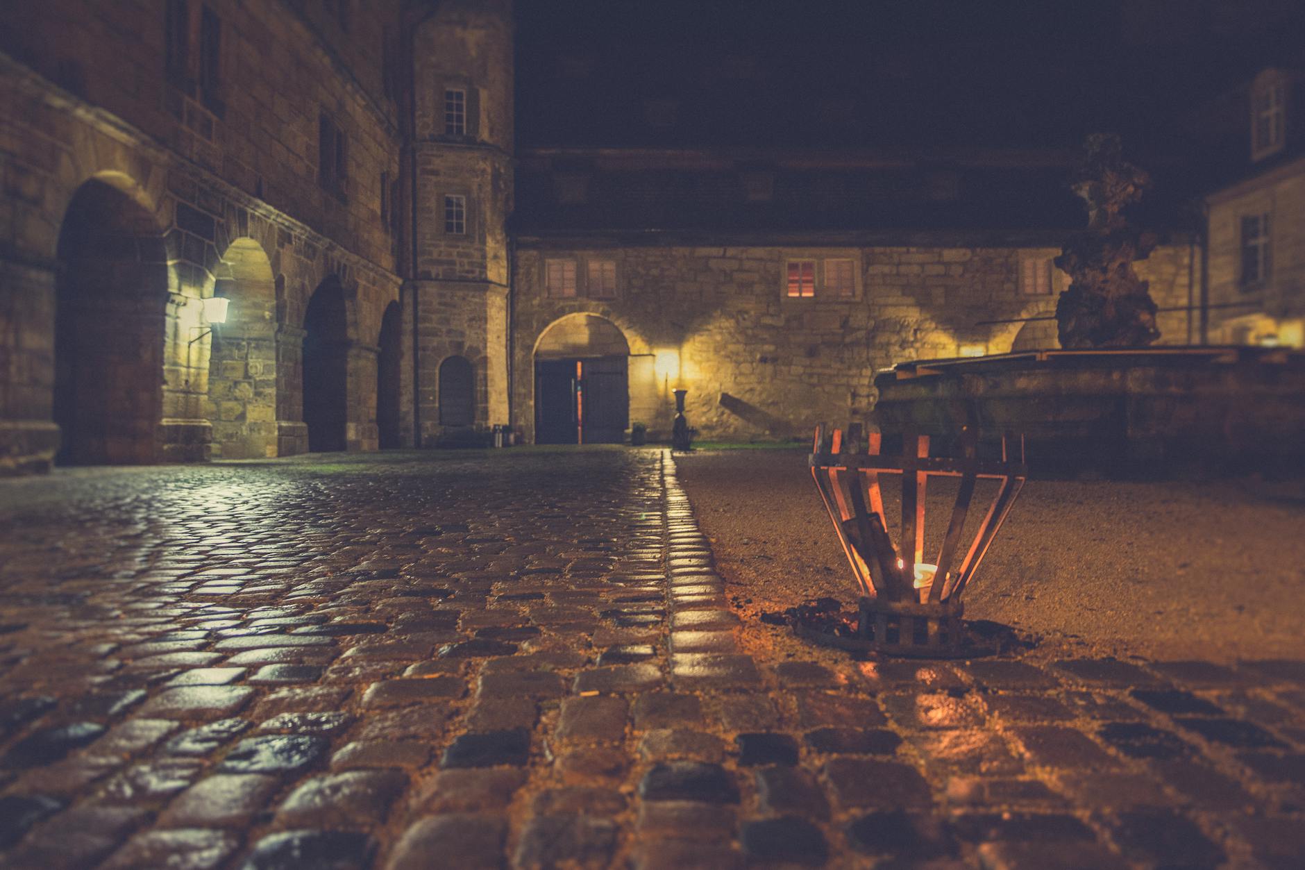 A peaceful medieval courtyard with whitewashed buildings and cobblestones