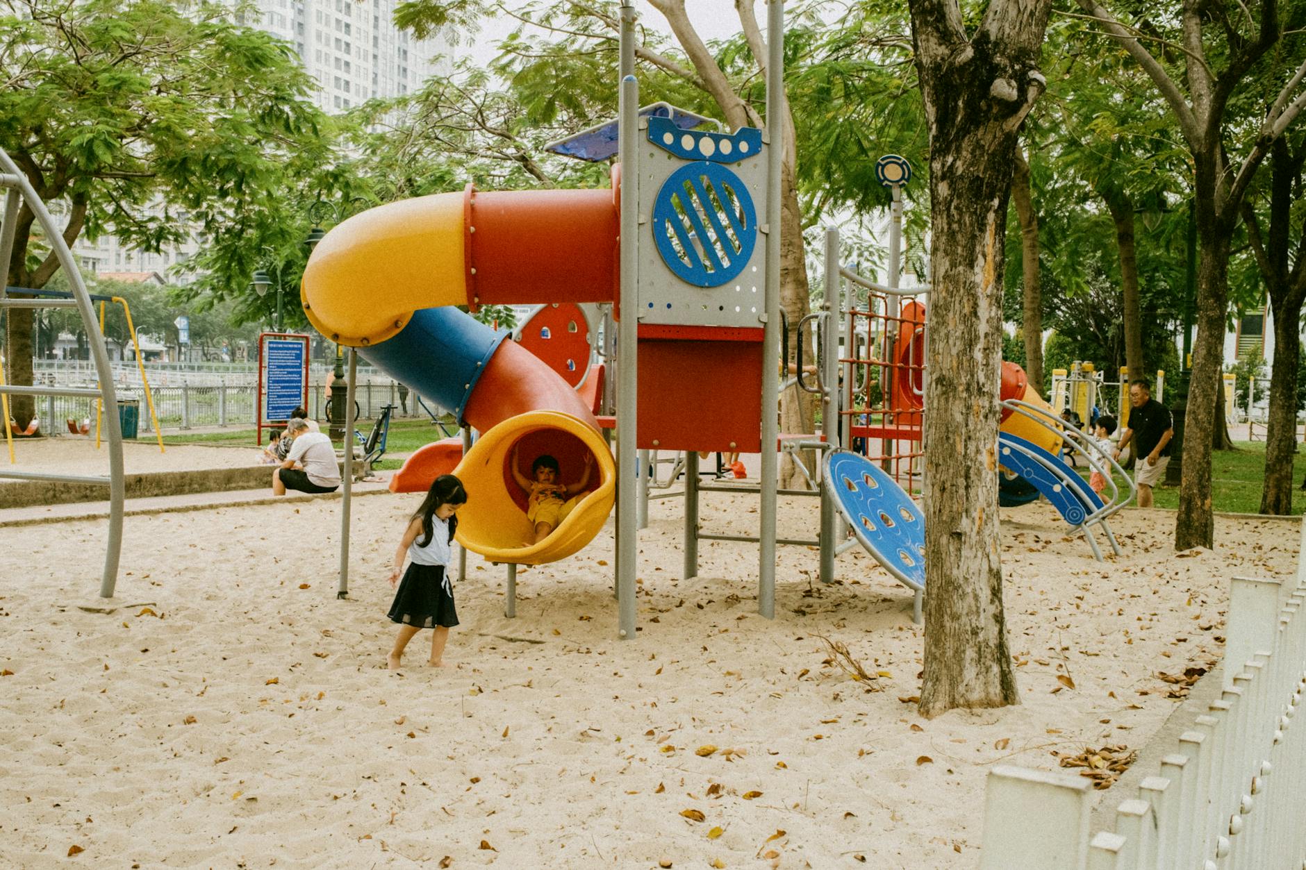 Children playing in a park playground on a sunny day