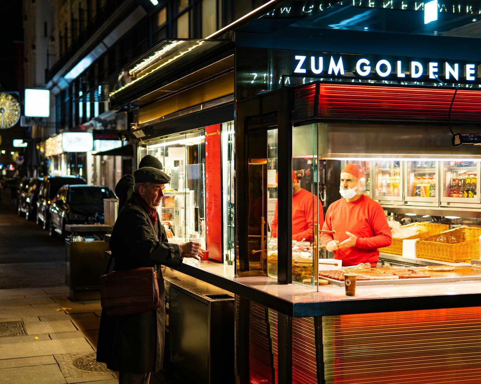 Late-night food scene on a European city street with illuminated restaurants