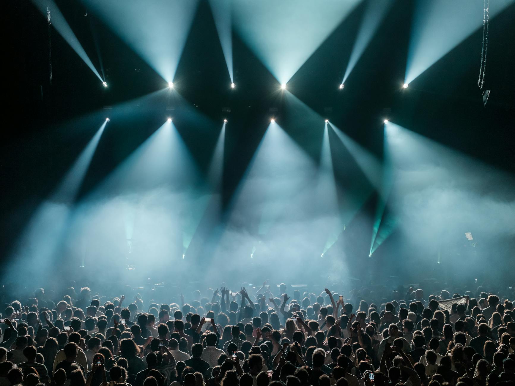 Live music concert performance in an indoor venue with enthusiastic audience