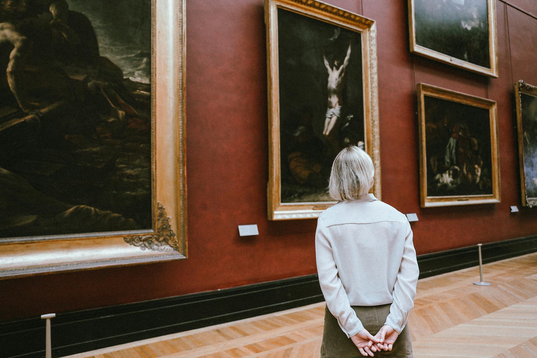 Visitors exploring an art museum gallery with paintings on the walls