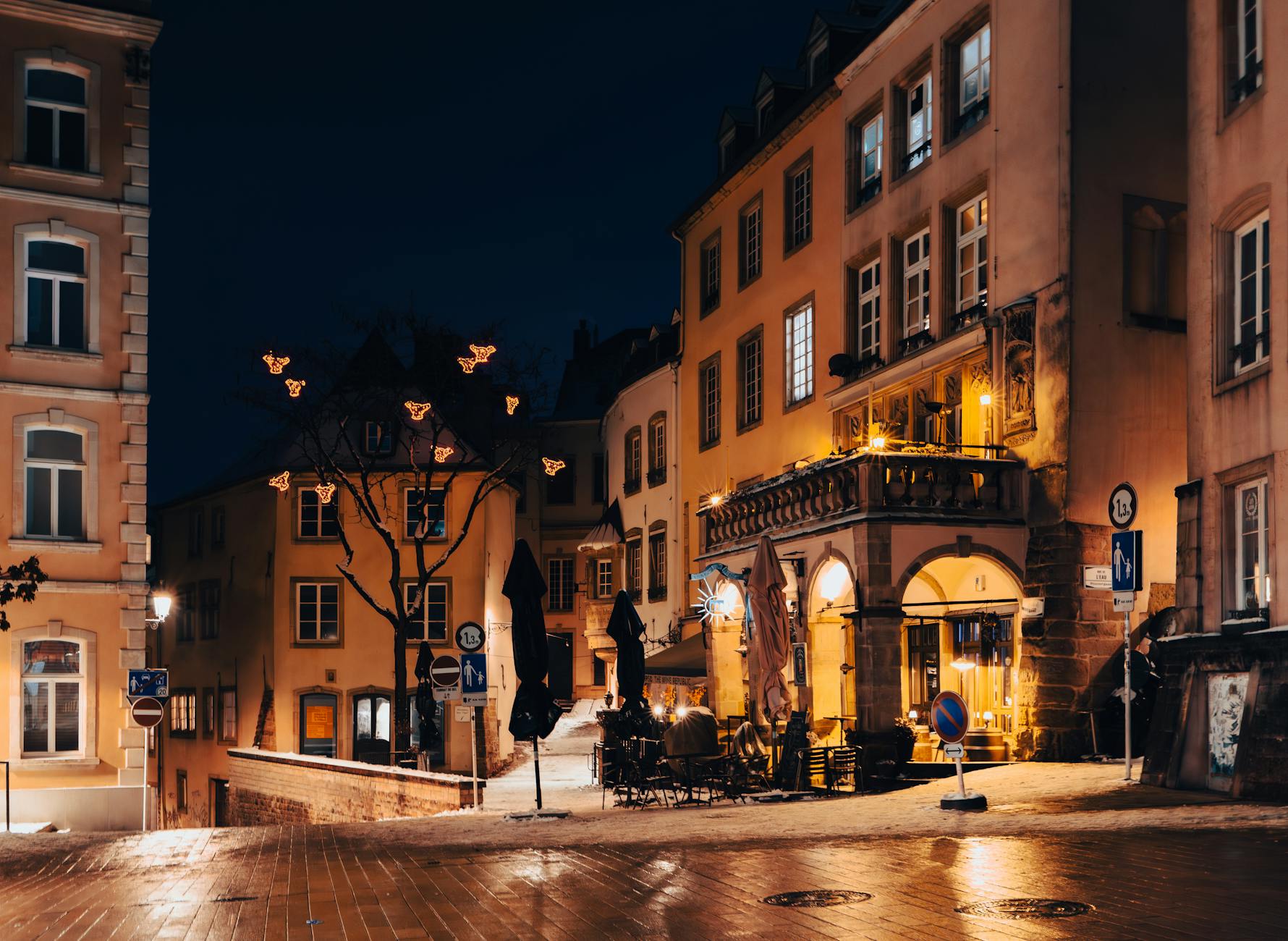 Busy nightlife street in a European city with illuminated bars and restaurants