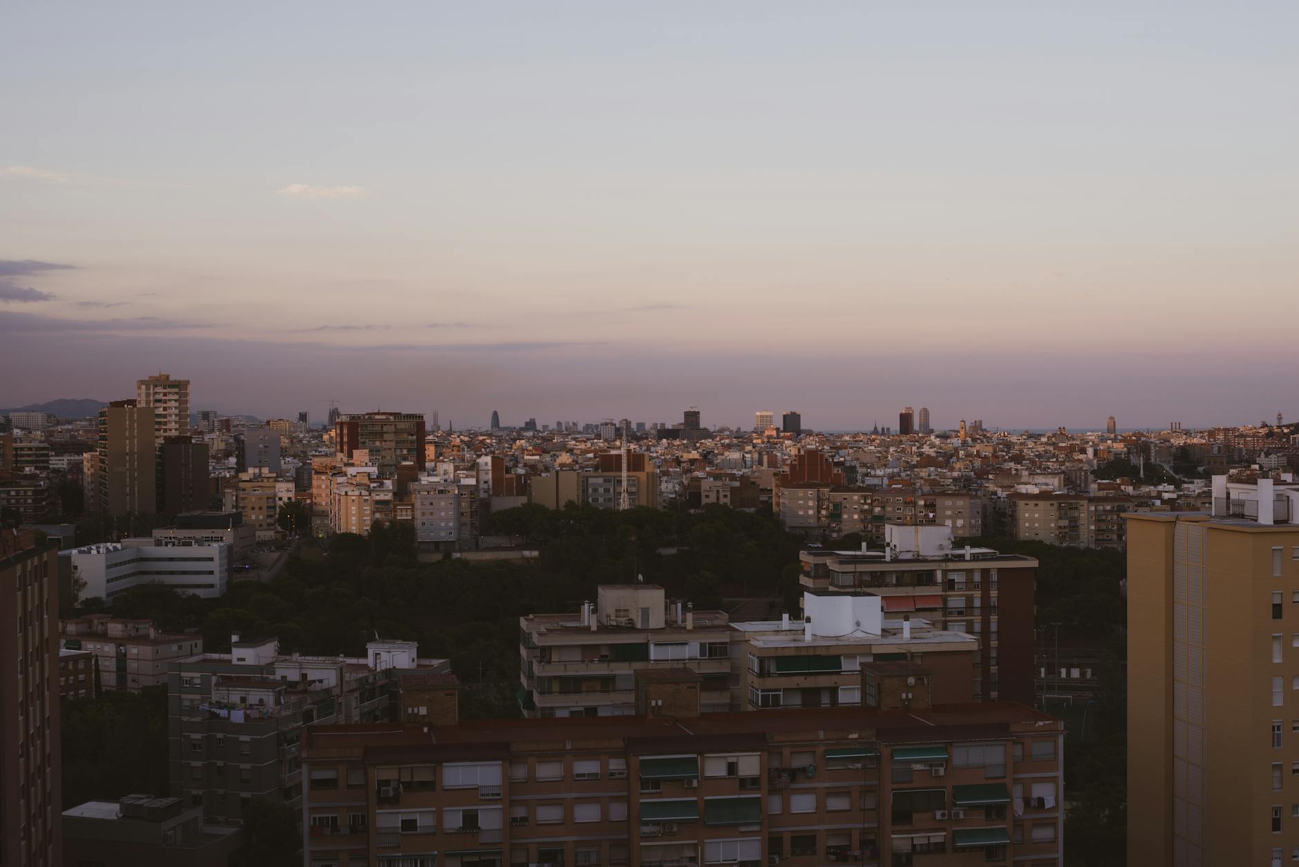 A panoramic sunset view over a European city skyline from an elevated viewpoint