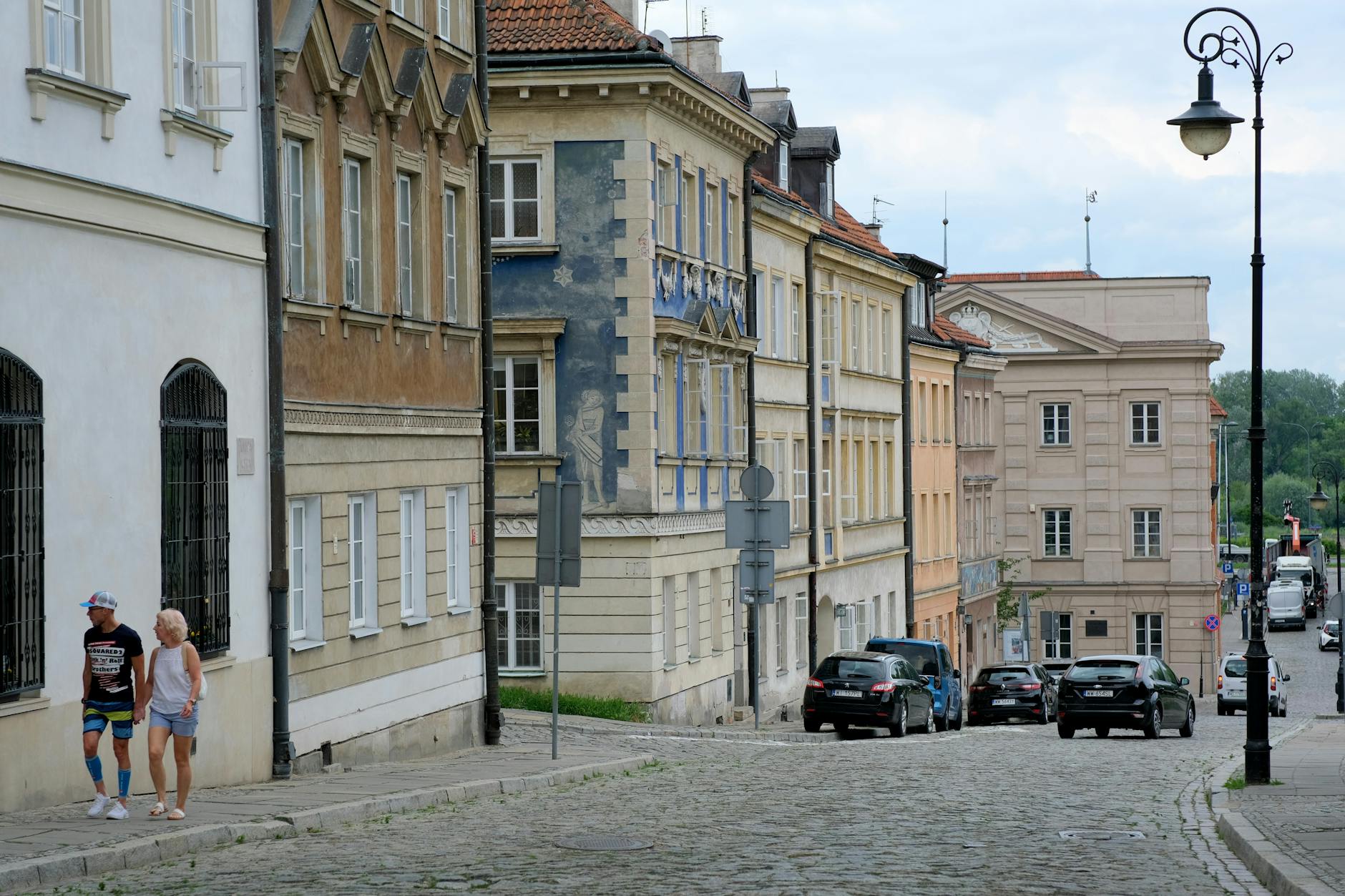 Tourists walking along a cobblestone street in a historic European city