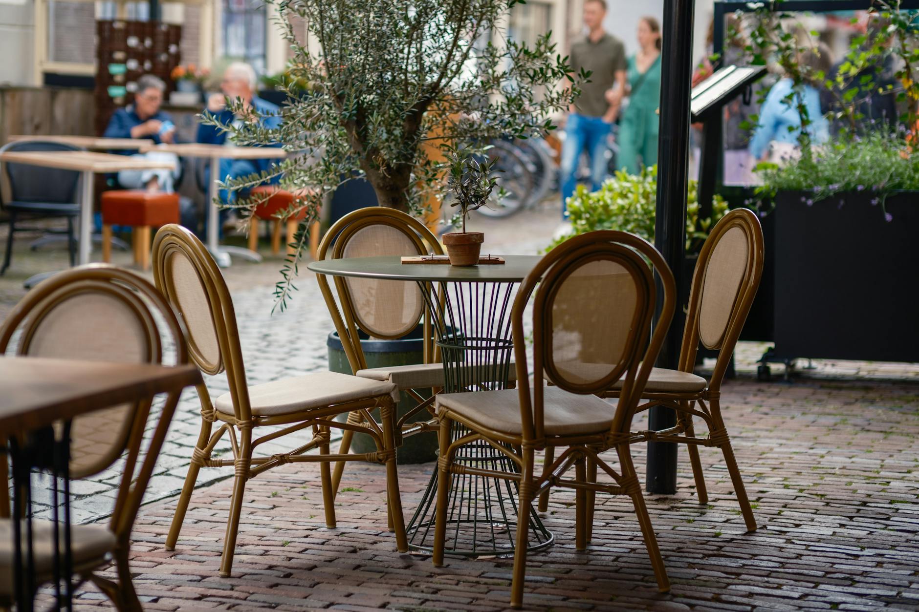 People enjoying coffee at an outdoor café terrace on a European street