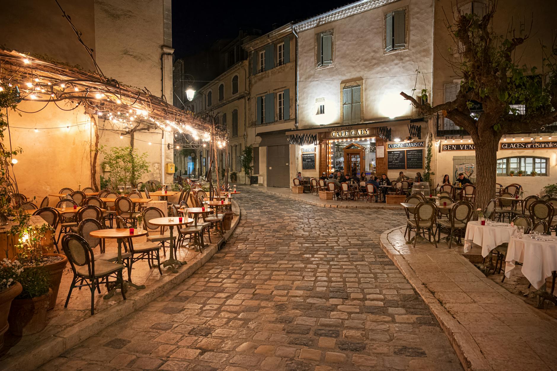 A charming cobblestone street with cafe terraces in a European neighbourhood