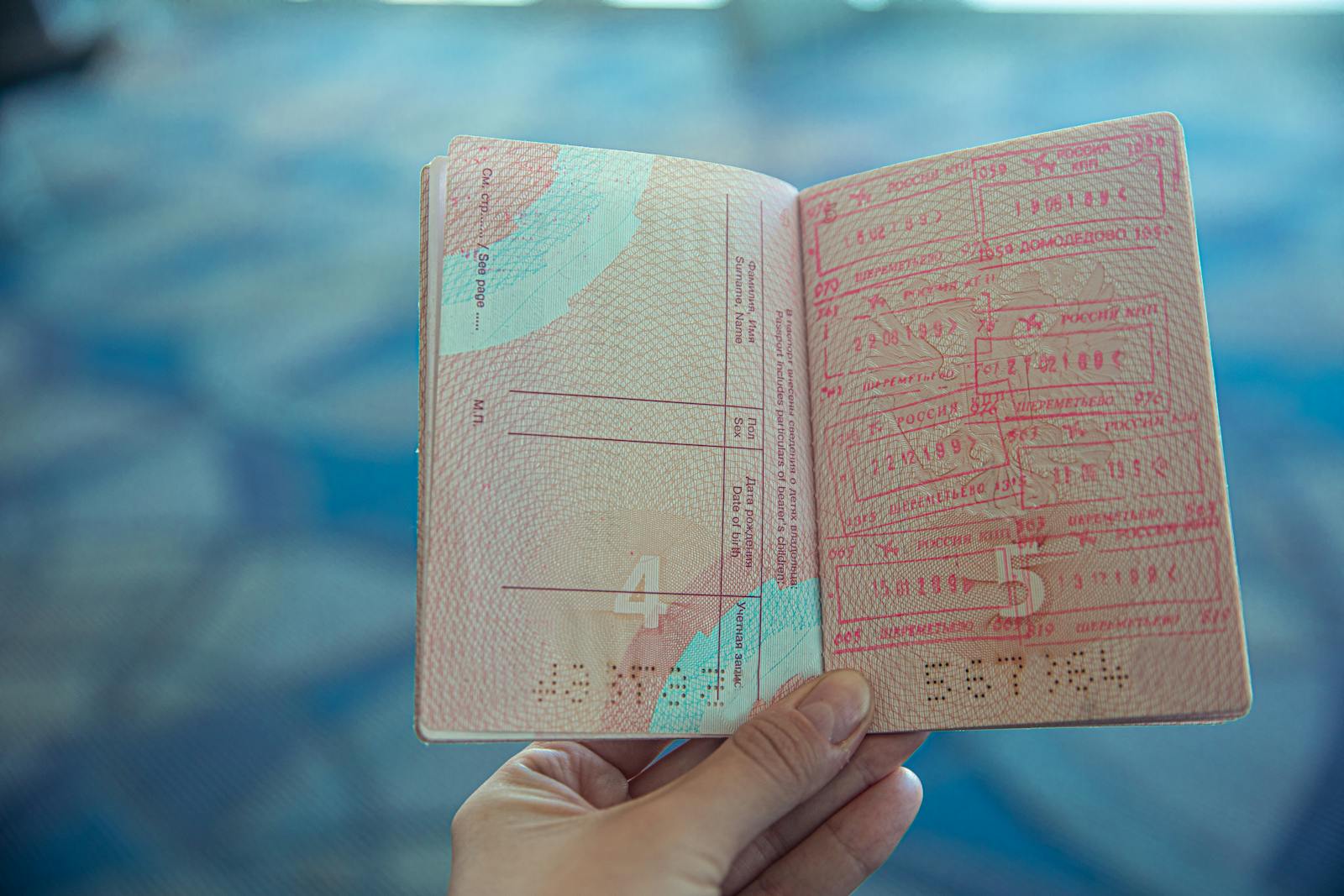 Tax free shopping Brussels — close-up view of open passport displaying travel stamps in airport setting