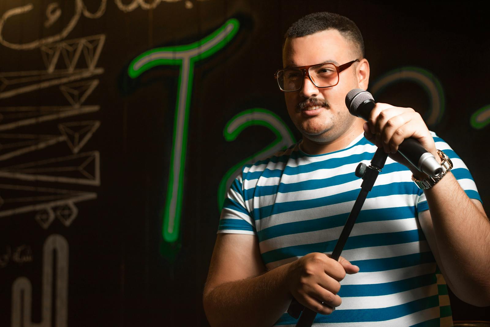 Brussels comedy shows — man holding microphone doing stand-up comedy on stage at Brussels comedy venue
