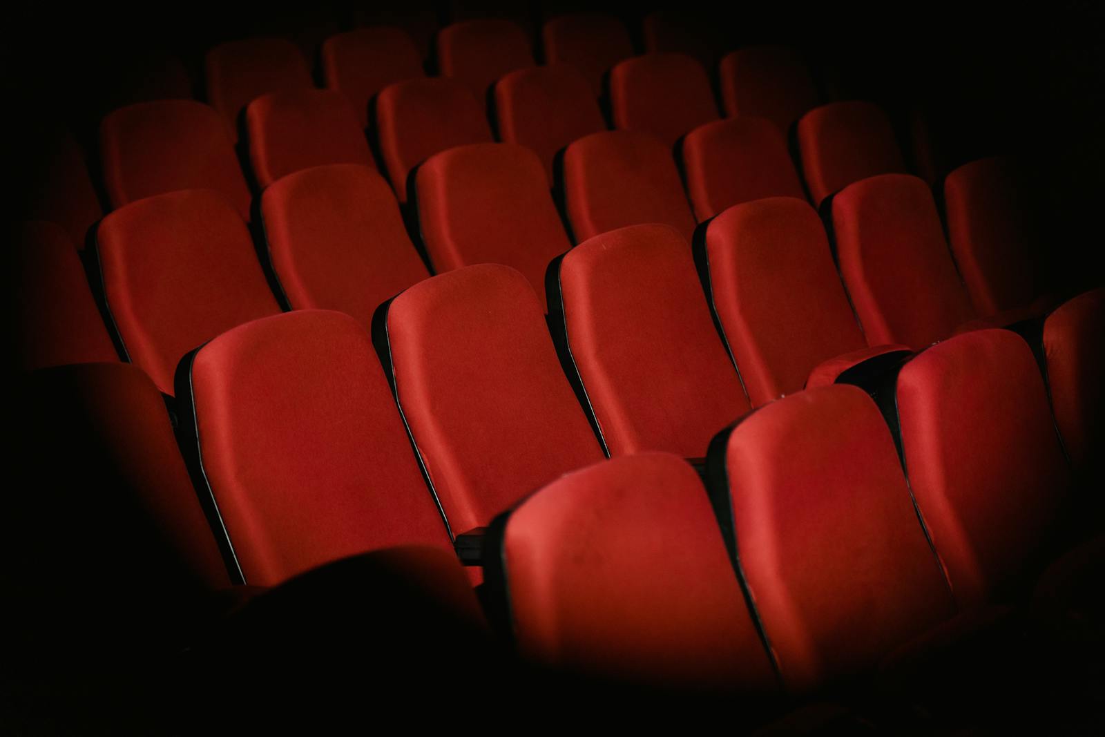 Brussels cinema film — rows of red armchairs in dimly lit cinema setting creating moody atmosphere