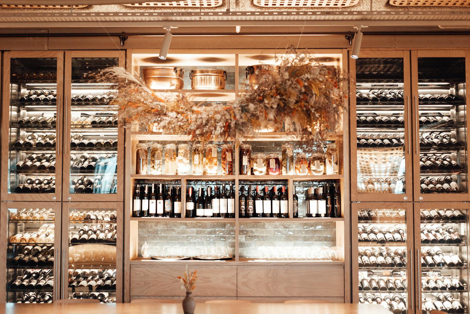 Wine bars Brussels — collection of wines in modern enoteca showcase with stylish furniture and warm lighting