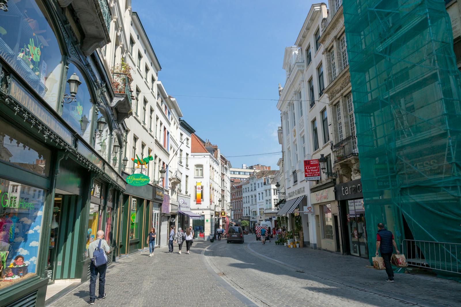 Walking in Brussels guide — best sunny day on bustling European street with shops, pedestrians, and classic architecture