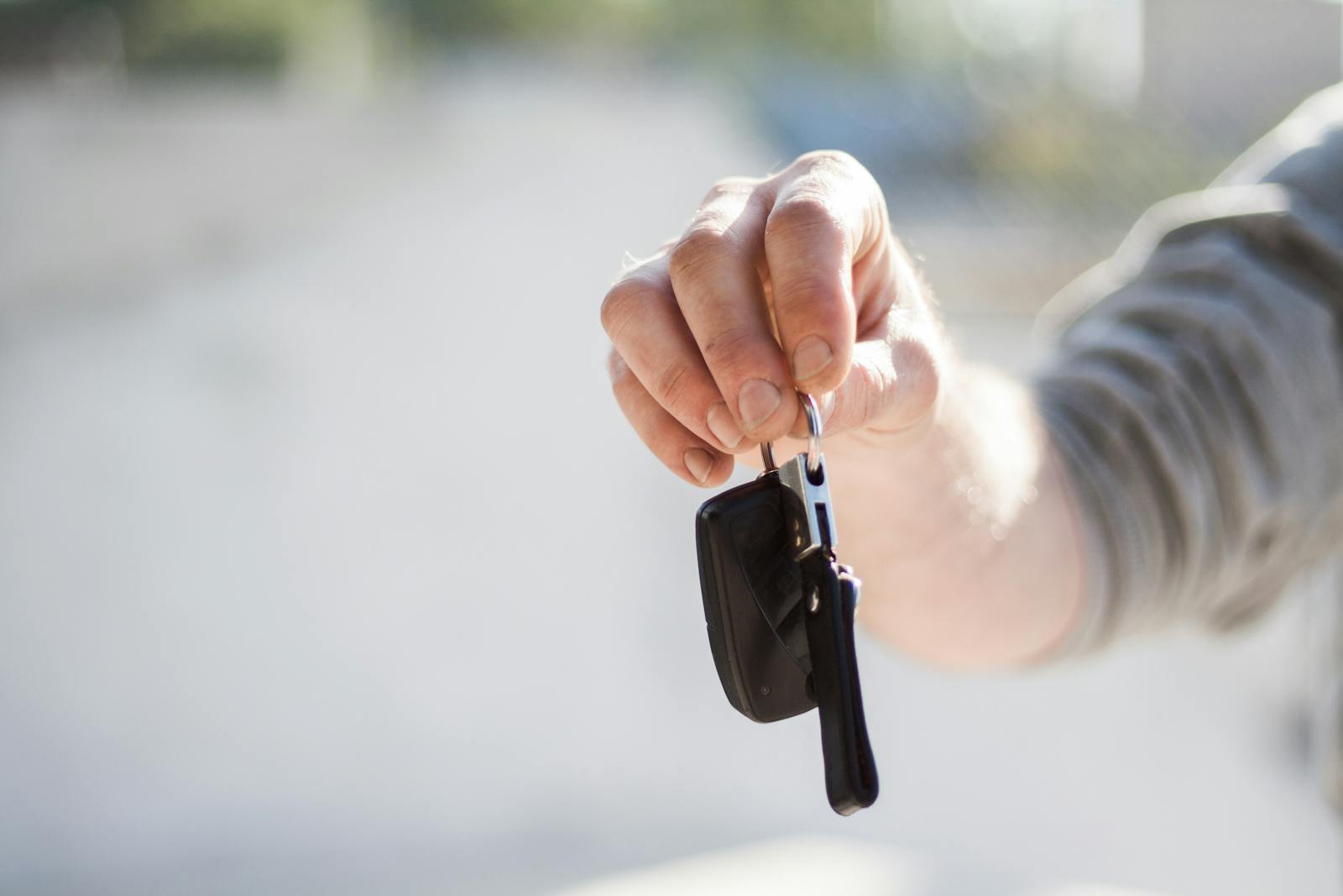 Car rental Brussels tips — best close-up of person handing car rental keys to customer at counter