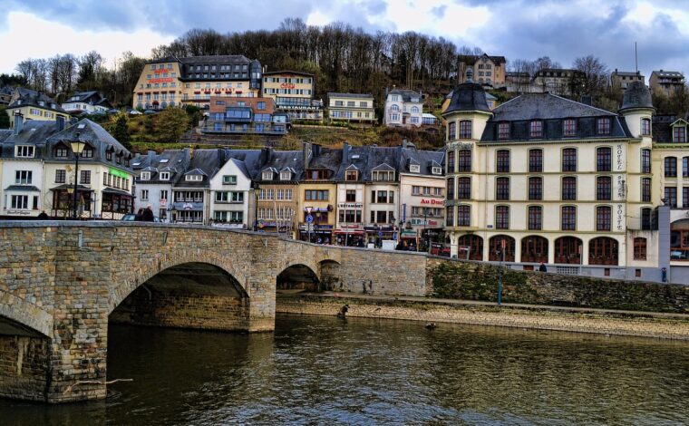 The stone bridge over the Semois at Bouillon with the town's hotels and restaurants rising up the wooded hillside behind