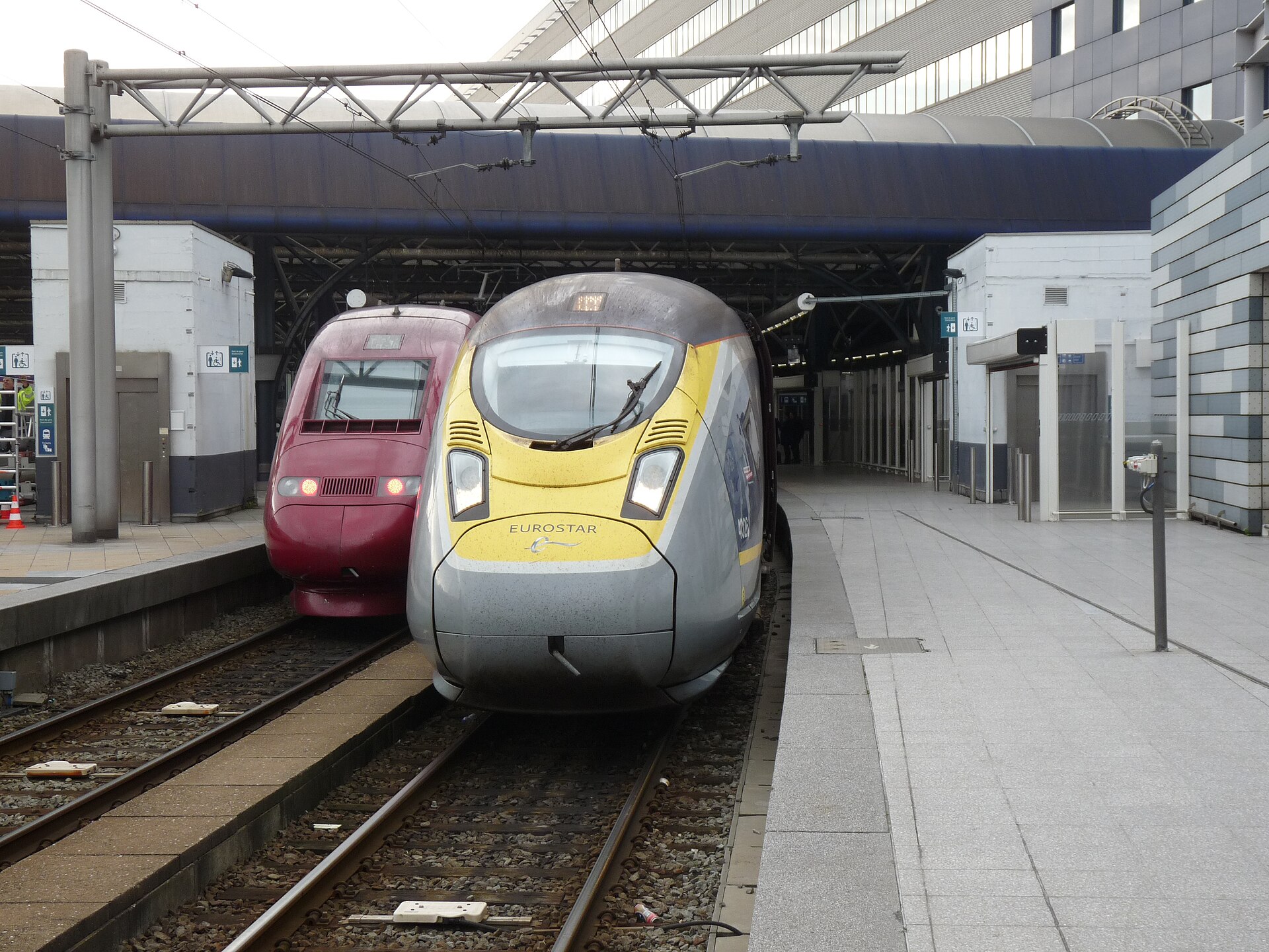 A Eurostar train alongside a red high-speed train at the international platforms in Brussels-Midi