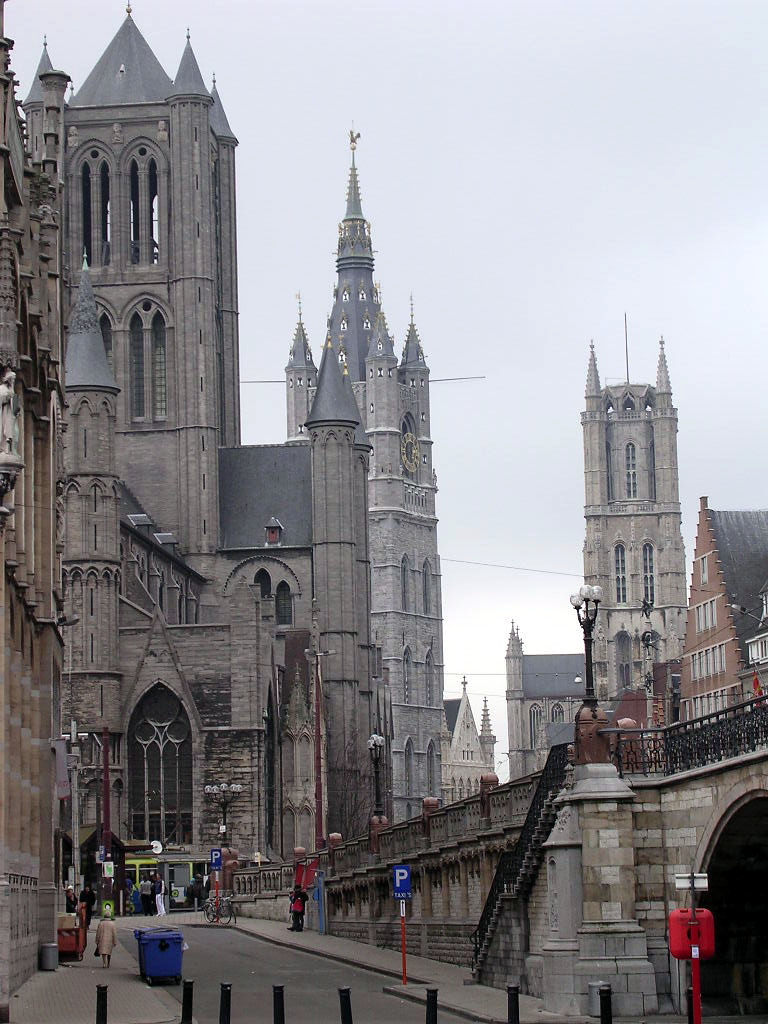The three towers of Ghent — Saint Nicholas Church, the Belfry and Saint Bavo's Cathedral — lined up along a street
