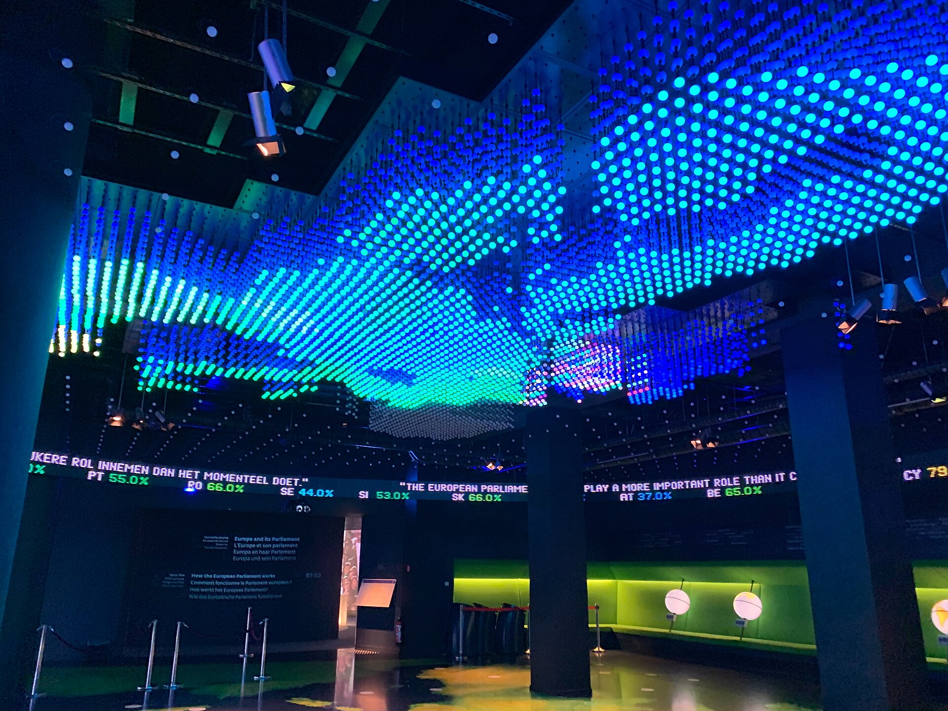 Blue lights hang above information stations and multilingual displays inside the Parlamentarium visitor centre at the European Parliament in Brussels.