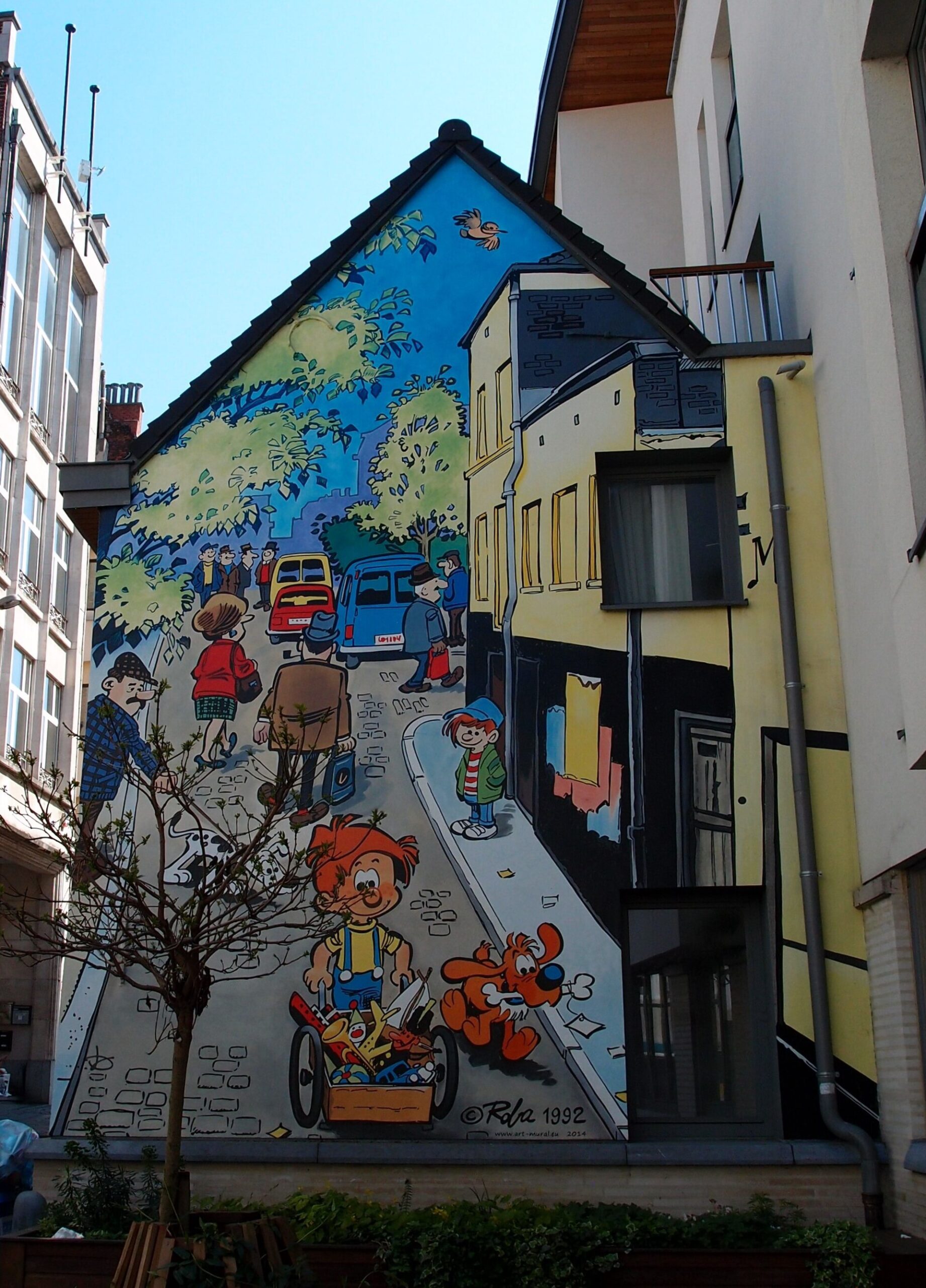 Boule pushes a toy cart beside Bill in a colorful gable mural on Rue du Chevreuil in Brussels.
