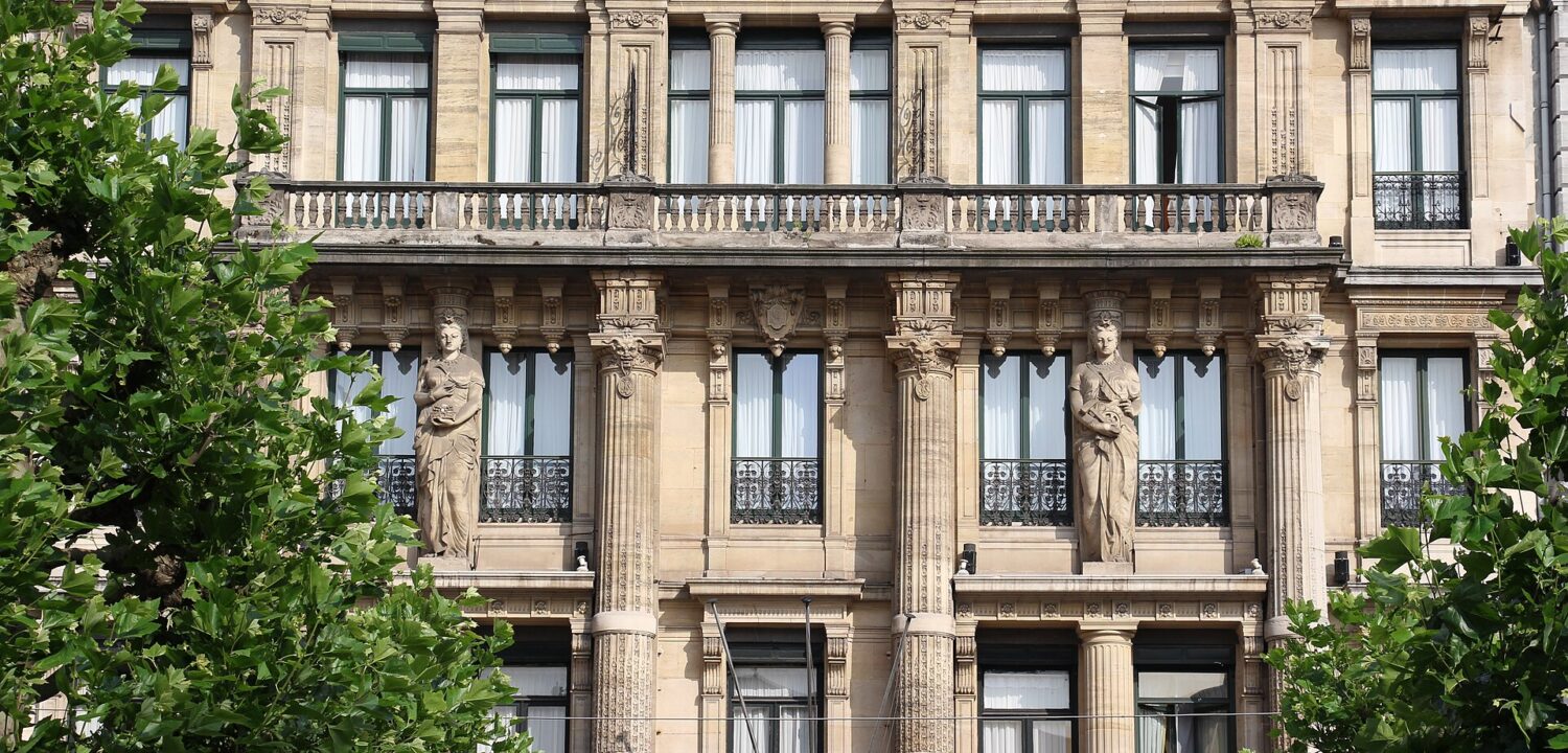 Carved figures, stone columns and balcony balustrades decorate the Hotel Metropole facade on Place de Brouckere in Brussels.