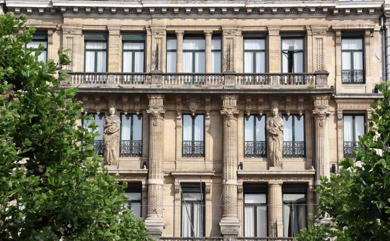 Carved figures, stone columns and balcony balustrades decorate the Hotel Metropole facade on Place de Brouckere in Brussels.