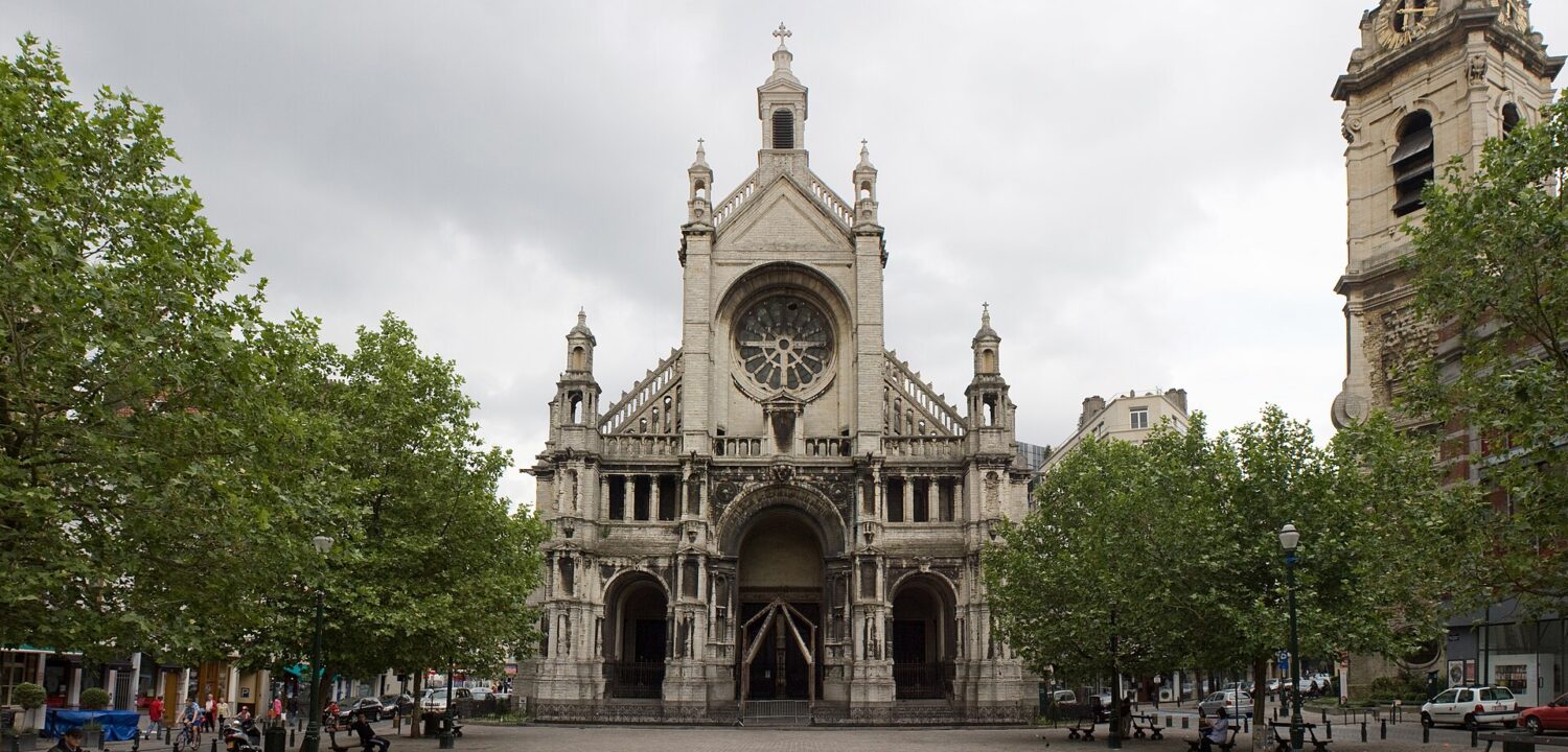 The Church of Sainte-Catherine faces a cobbled Brussels square, with leafy trees, benches and its separate clock tower at right.