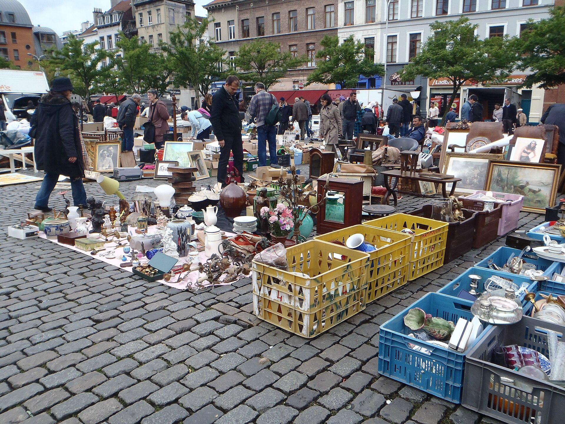 Crates of crockery, lamps and framed pictures fill the cobbled Place du Jeu de Balle in Brussels as shoppers browse between stalls.