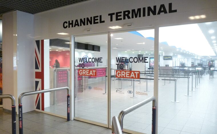 Glass doors mark the Eurostar Channel Terminal entrance at Brussels-Midi, with British flag graphics and queue barriers inside.
