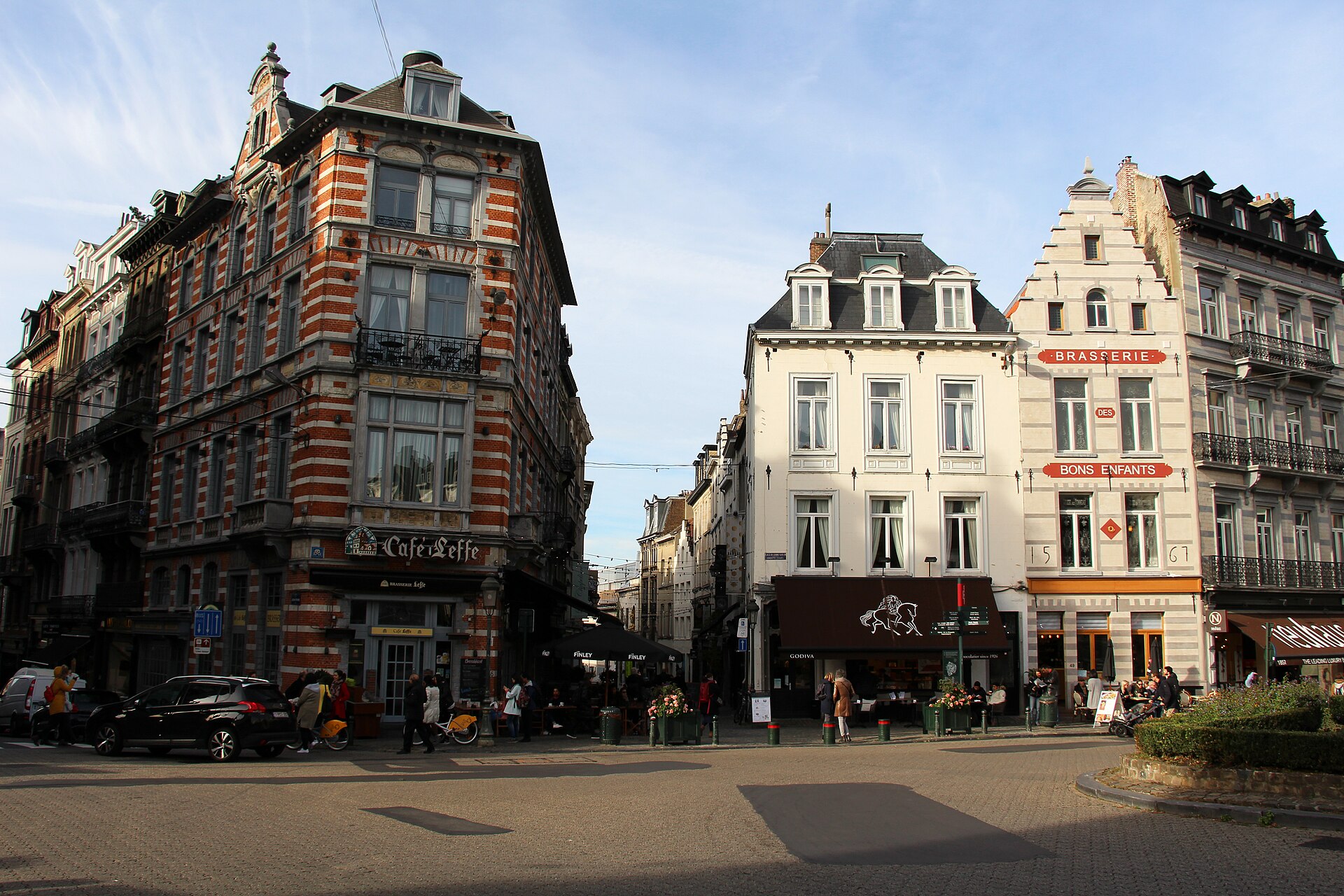 The Godiva chocolate shop faces Place du Grand Sablon in Brussels beside cafe terraces and ornate brick and stone facades.