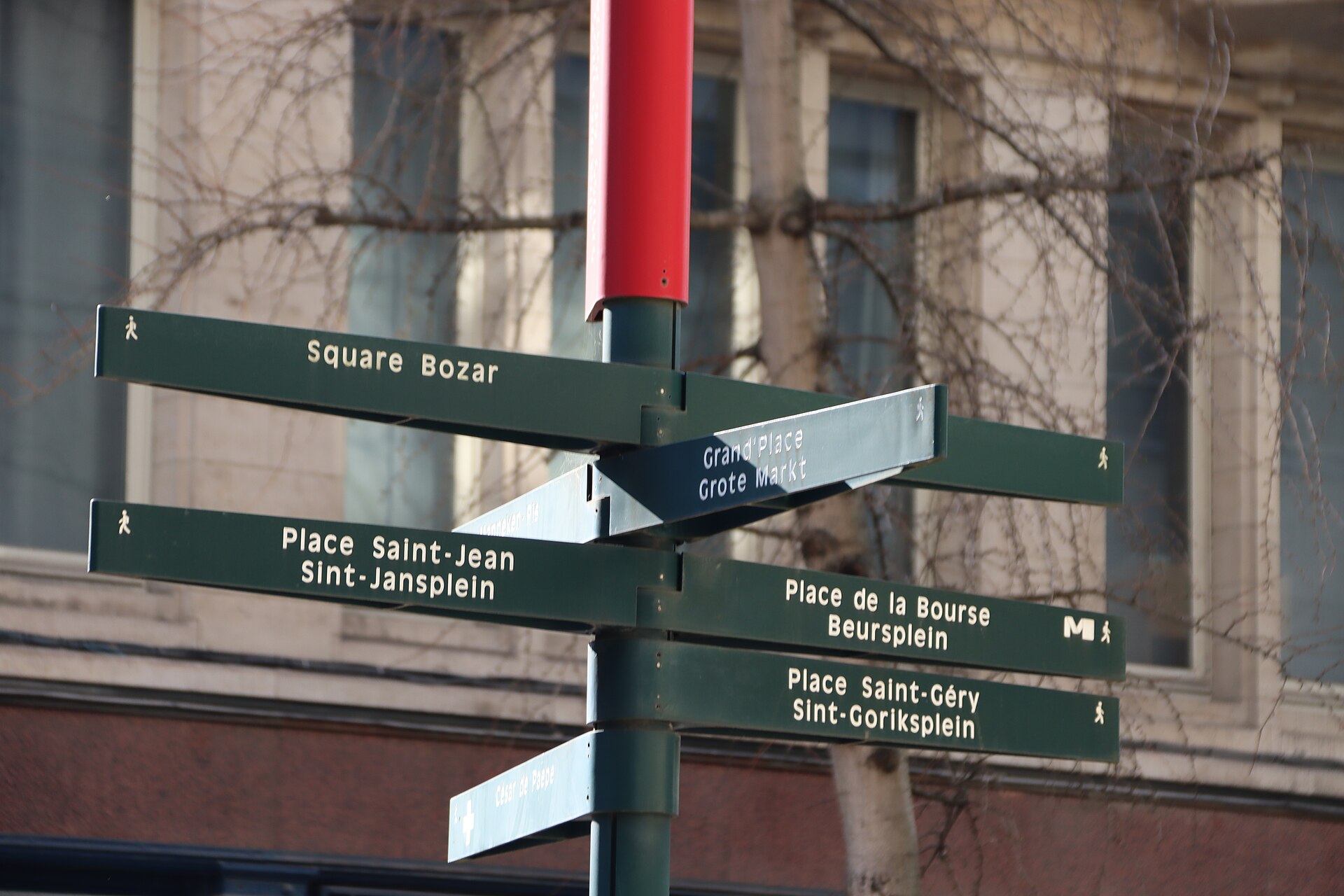 Green pedestrian signposts in Brussels point towards Grand Place, Place de la Bourse and Place Saint Gery using French and Dutch names.