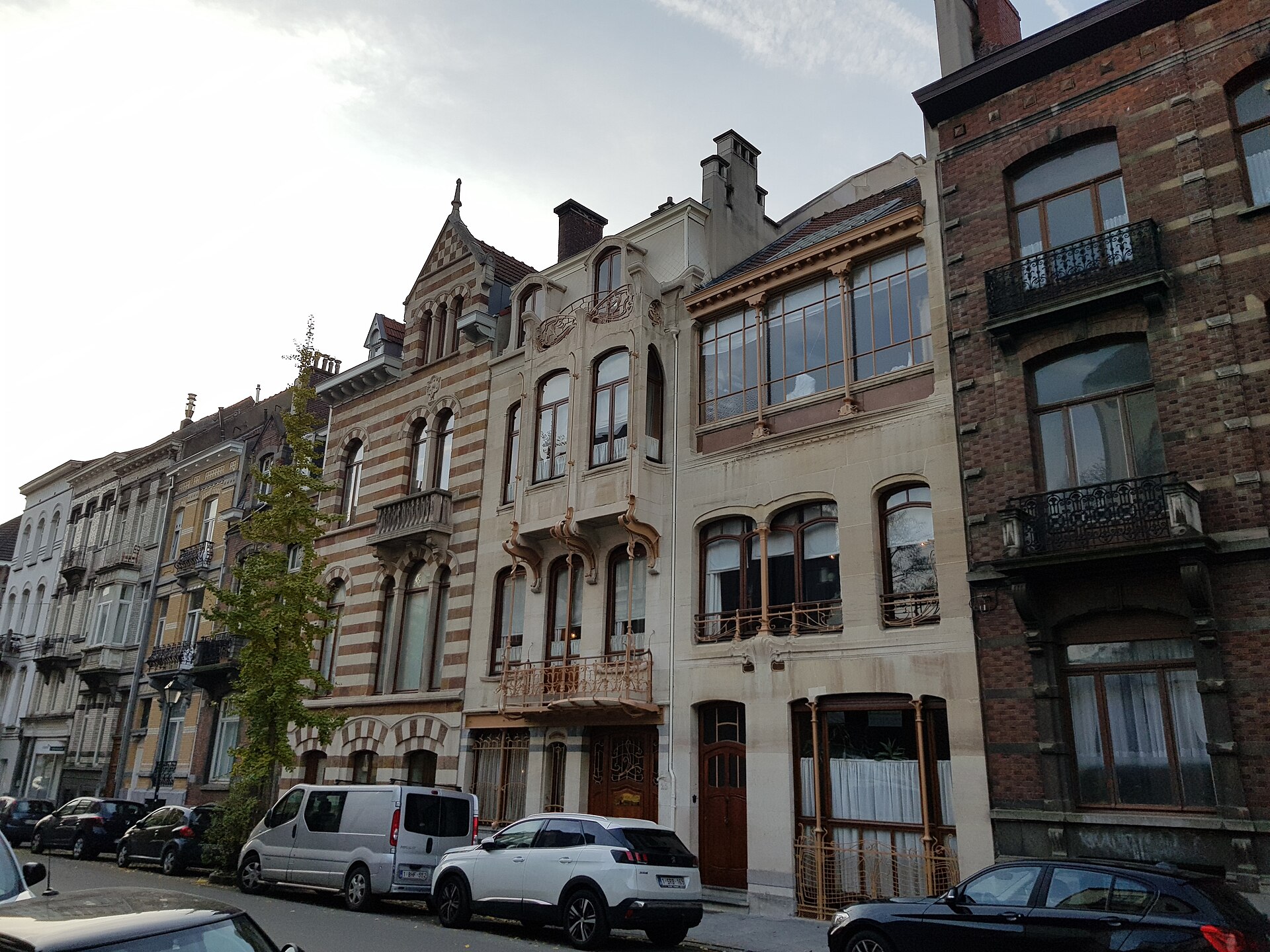 The Horta Museum in Brussels combines a pale stone townhouse with curved balconies and an adjoining studio with broad upper windows.