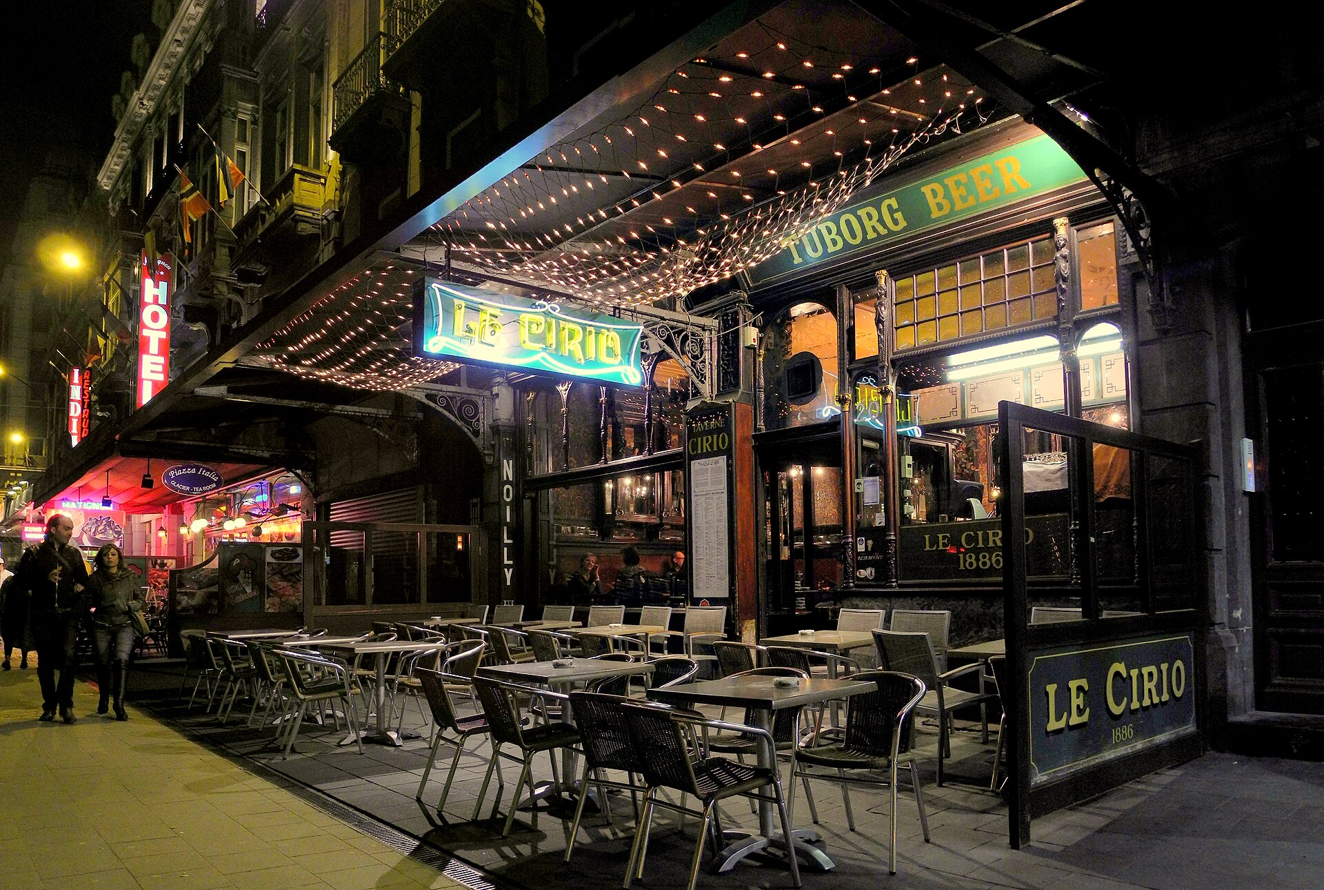 Le Cirio's illuminated sign and canopy shine above empty pavement tables outside the historic cafe on Rue de la Bourse in Brussels.