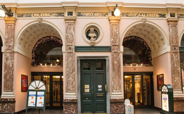 Marble columns and illuminated arches frame the Theatre Royal des Galeries entrance inside Brussels' Saint-Hubert galleries.