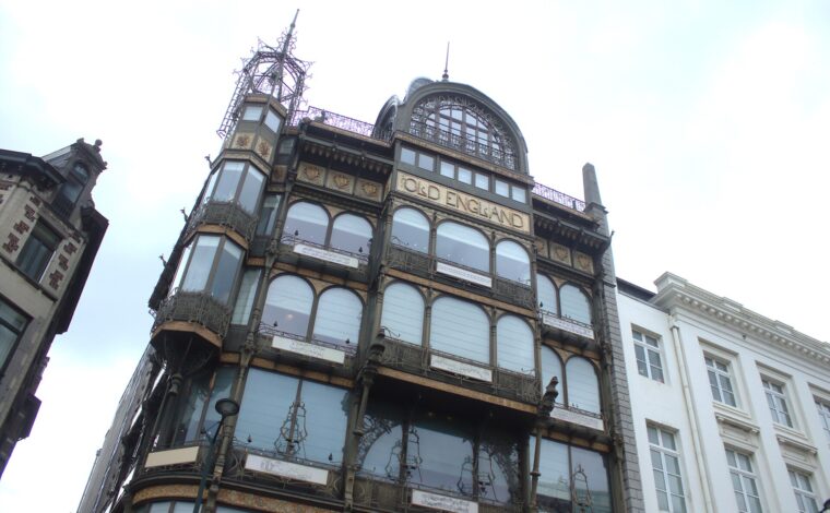 The Musical Instruments Museum in Brussels occupies Old England, whose iron and glass facade rises beside a white neighbouring building.