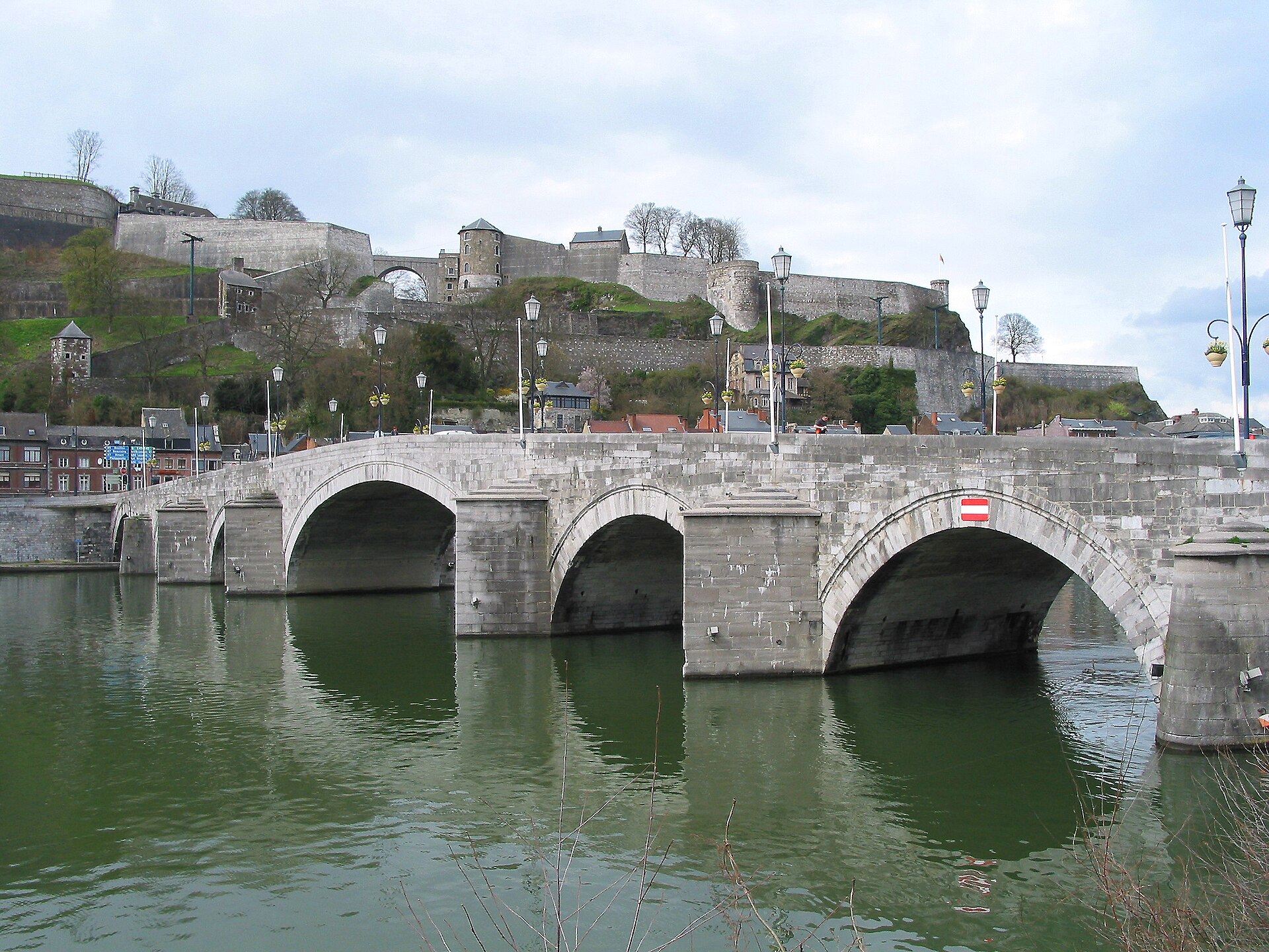 Namur’s citadel rises in tiers above the Meuse behind the stone arches of the Pont de Jambes.