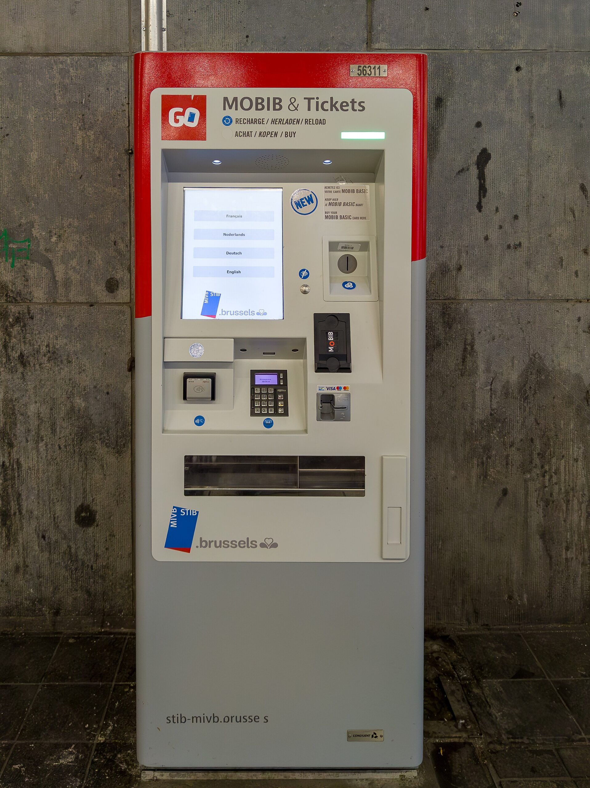 A red and grey STIB GO ticket machine in Brussels displays language choices above its payment controls and MOBIB reader.