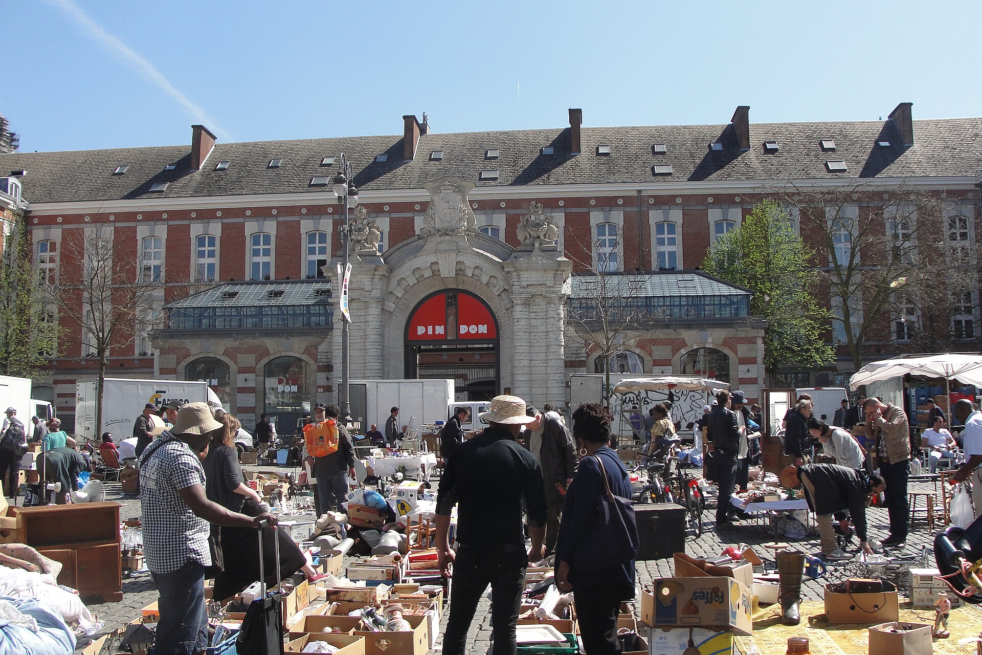 Shoppers examine boxes of household goods at Brussels Place du Jeu de Balle, in front of the former fire station.