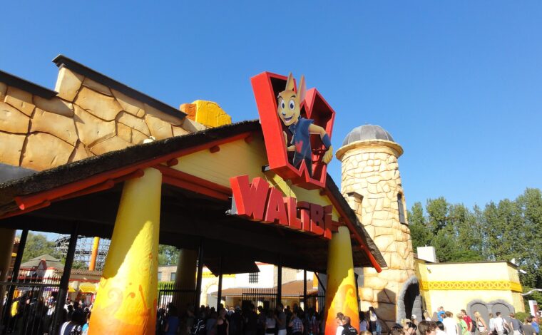 Visitors queue beneath the red Walibi sign and kangaroo mascot at the colourful entrance to Walibi Belgium in Wavre.